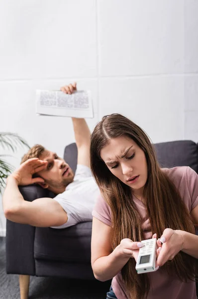Sad Couple Remote Controller Newspaper Suffering Heat While Sitting Home — Stock Photo, Image