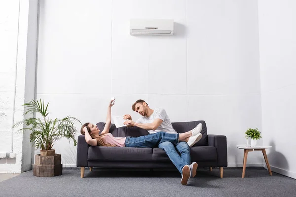 Sad Young Couple Remote Controller Suffering Heat Home Broken Air — Stock Photo, Image