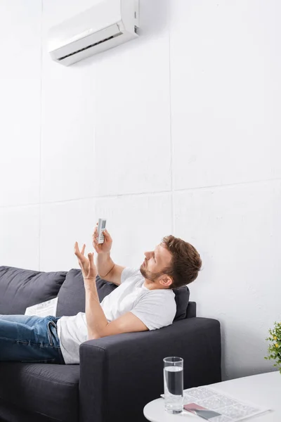 Homem Confuso Tentando Ligar Condicionado Com Controle Remoto Casa — Fotografia de Stock