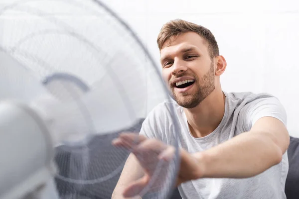 Jóképű Pozitív Férfi Érzés Kényelmes Elektromos Ventilátor Otthon Nyári Melegben — Stock Fotó