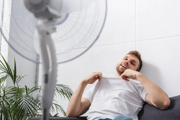 Positive Man Feeling Comfortable Electric Fan Home Summer Heat — Stock Photo, Image