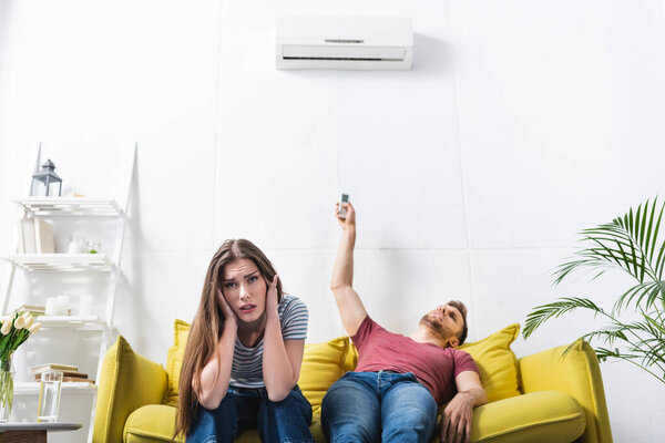 exhausted couple sitting home with broken air conditioner