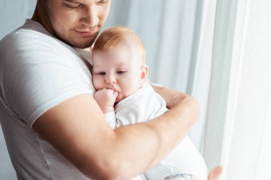 Mutlu, genç bir baba kucağına alıp kucaklıyor. 