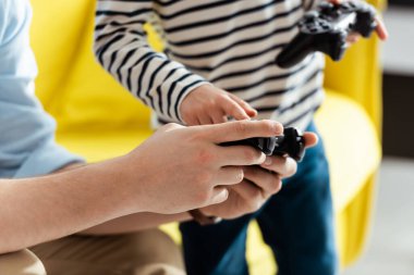 KYIV, UKRAINE - 9 Haziran 2020: Oğluna joystick gösteren adamın kısmi görüntüsü