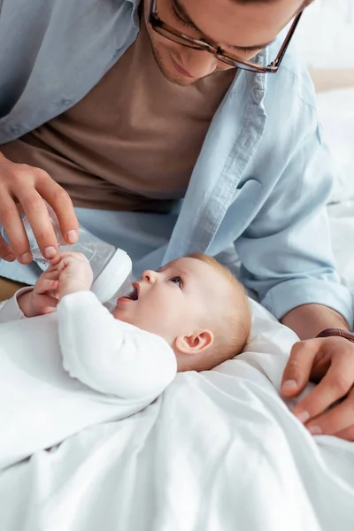 Young Father Feeding Adorable Son Baby Bottle Bed — Stock Photo, Image