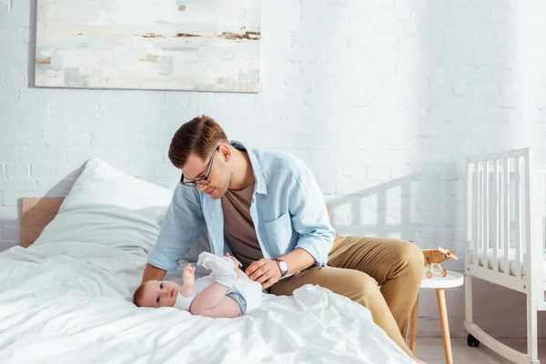 Glücklicher Junger Vater Berührt Niedlichen Jungen Der Strampler Auf Dem — Stockfoto