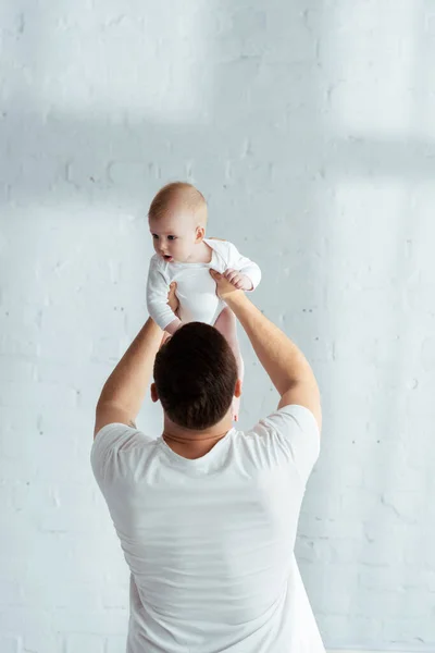 Baksida Bild Far Håller Bedårande Liten Pojke Utsträckta Händer — Stockfoto