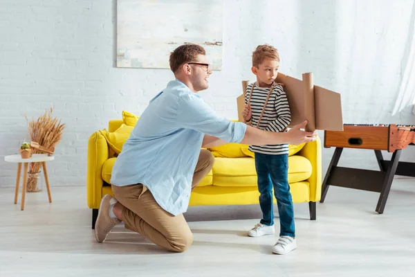 Young Father Fixing Carton Plane Wings Back Adorable Son — Stock Photo, Image