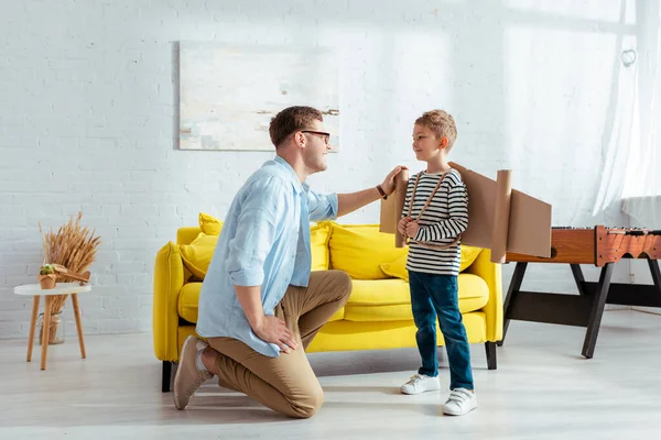 Young Father Stand Knee Happy Son Carton Wings Back — Stock Photo, Image