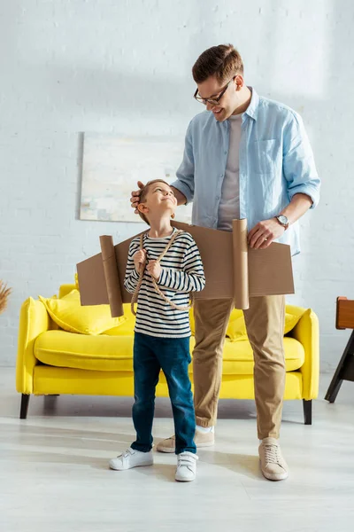 Smiling Father Giving High Five Happy Son Carton Wings Back — Stock Photo, Image