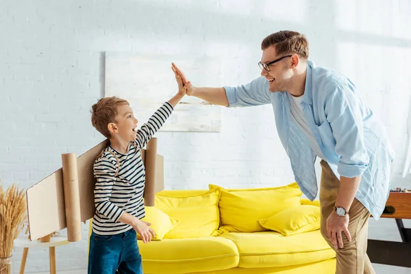 Cute Boy Cardboard Plane Wings Back Giving High Five Father — Stock Photo, Image