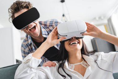 Cheerful couple using virtual reality headsets at home  clipart