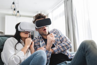 Koltukta vr kulaklık kullanan korkmuş genç çiftin seçici odak noktası 
