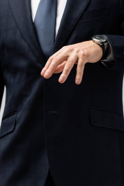 cropped view of businessman in suit manipulating with hand isolated on grey clipart