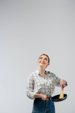 Spatula ve kızartma tavasıyla kukla gibi poz veren çekici bir kız.