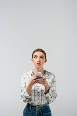 Akıllı telefon kullanan ve izole edilmiş griye bakan çekici bir kız.