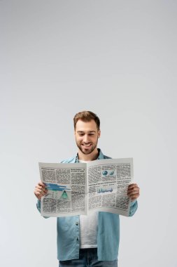 Gri renkte gazete okuyan gülümseyen genç adam
