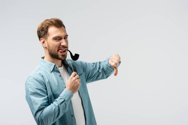 Sahte tütün piposu olan komik genç adam Grinin üstünde parmağını gösteriyor.