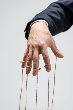 partial view of puppeteer with strings on fingers isolated on grey clipart