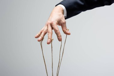 cropped view of puppeteer with strings on fingers isolated on grey clipart