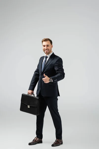 Lächelnder Geschäftsmann Mit Lederkoffer Daumen Hoch Auf Grau — Stockfoto