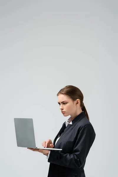 困惑的年轻女商人使用灰色的笔记本电脑 — 图库照片