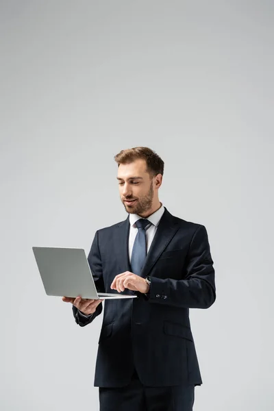 Homem Negócios Bonito Terno Usando Laptop Isolado Cinza — Fotografia de Stock