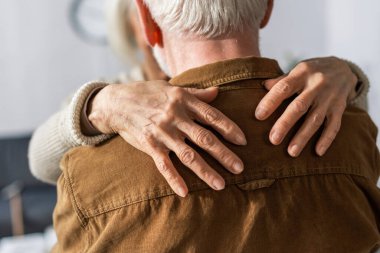 back view of senior man embraced by wife clipart