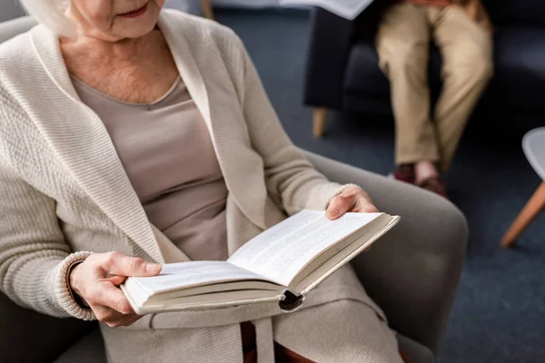 Cropped View Senior Woman Reading Book Husband Selective Focus — Stock Photo, Image