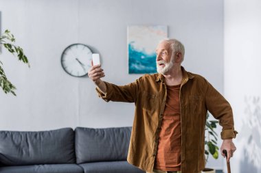 Akıllı telefondan selfie çekerken gülümseyen heyecanlı son sınıf öğrencisi.