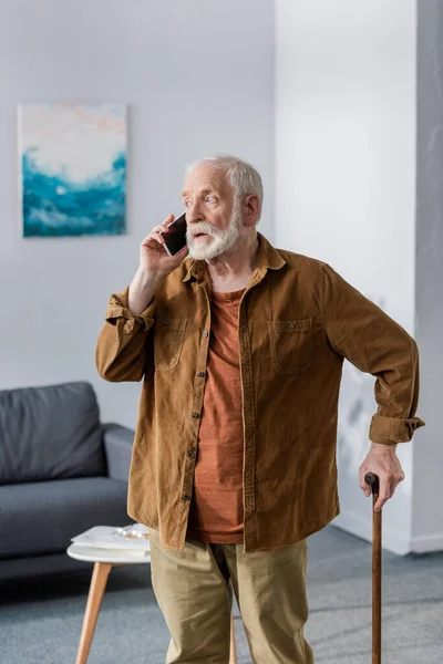 Chockad Senior Man Talar Smartphone När Står Med Promenadkäpp — Stockfoto