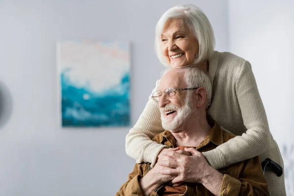 Χαρούμενη Ηλικιωμένη Γυναίκα Που Αγκαλιάζει Ευτυχισμένο Ανάπηρο Σύζυγο — Φωτογραφία Αρχείου