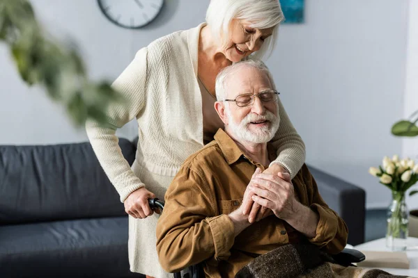 Focalizzazione Selettiva Della Donna Sorridente Che Abbraccia Marito Felice Disabile — Foto Stock