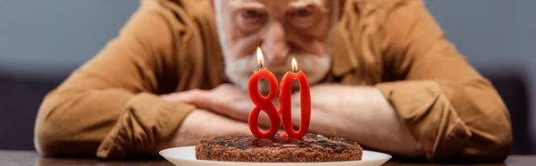 80番水平方向のイメージでお誕生日ケーキを見る孤独な老人の選択的焦点 — ストック写真
