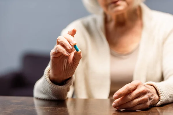 高齢女性が丸薬を飲み選択的焦点を当て — ストック写真