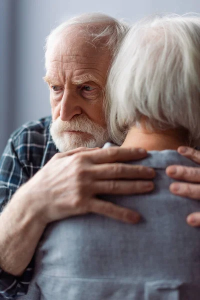 Homem Idoso Sofrendo Demência Abraçando Esposa Olhando Para Longe — Fotografia de Stock