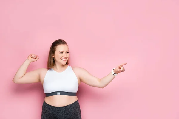 Glad Överviktig Flicka Pekar Med Fingret Och Tittar Bort Rosa — Stockfoto