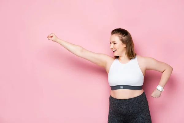 Excited Overweight Girl Showing Winner Gesture While Looking Away Pink — Stock Photo, Image