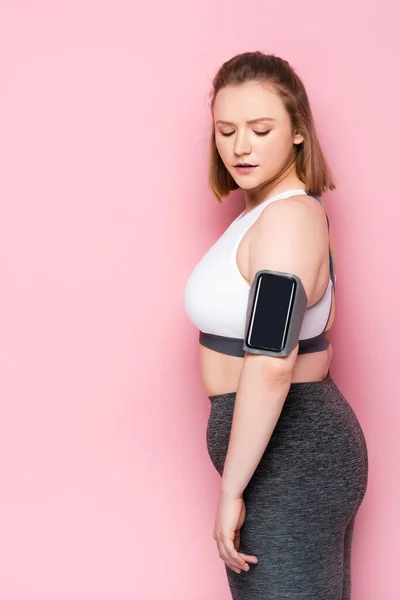 Pretty Overweight Girl Looking Smartphone Armband While Standing Pink — Stock Photo, Image