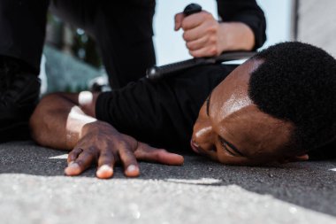 Sopa ve ırkçılık kavramlarıyla polisin yanında yatan Afrikalı Amerikalı adamın seçici odak noktası 