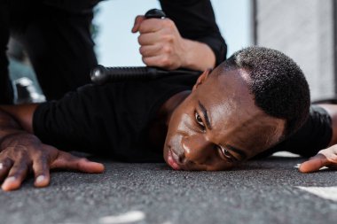Gözaltında tutulan Afrikalı Amerikalı adamın polis memurunun yanında copla yatması, ırkçılık kavramı 