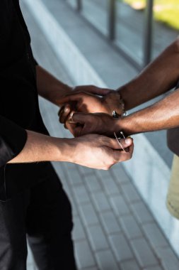 Polis memurunun kelepçelenmiş Afro-Amerikan bir adamın ellerine dokunduğunu gördüm. 