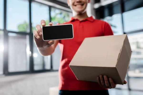 Kesilmiş Mutlu Teslimatçı Elinde Boş Ekran Karton Kutuyla Akıllı Telefon — Stok fotoğraf