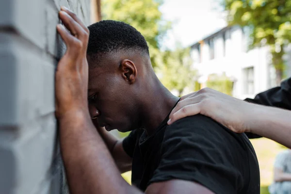 アフリカ系アメリカ人男性を路上に拘束する警察官の選択的焦点 — ストック写真