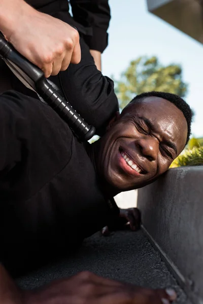 Селективный Фокус Задержанного Африканского Американца Страдающего Боли Лежащего Земле Рядом — стоковое фото