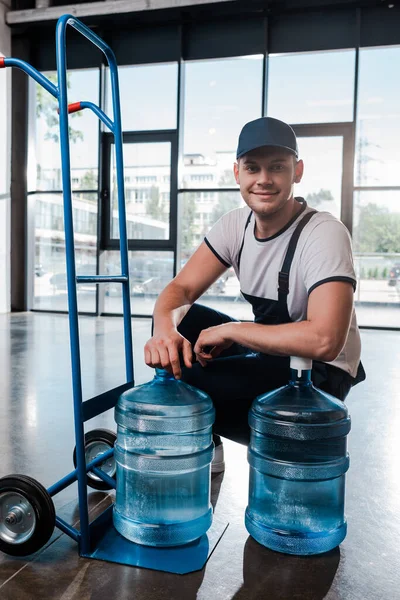 Happy Delivery Man Uniform Zitten Buurt Van Hand Truck Met — Stockfoto