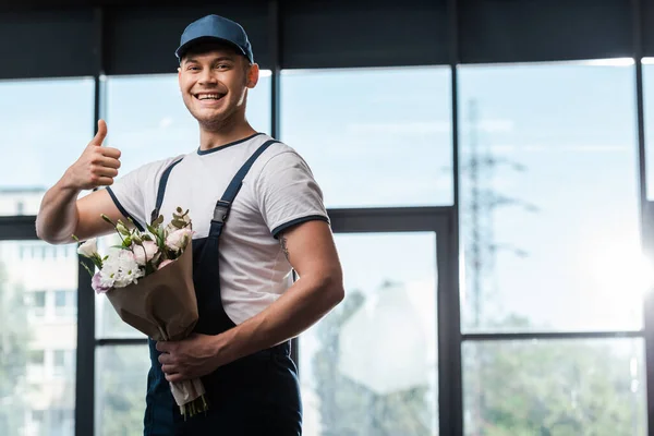 Gelukkig Levering Man Uniform Pet Tonen Duim Omhoog Houden Boeket — Stockfoto