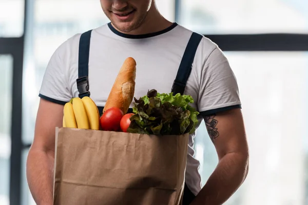 Cropped View Cheerful Delivery Man Holding Paper Bag Groceries — Stock Photo, Image