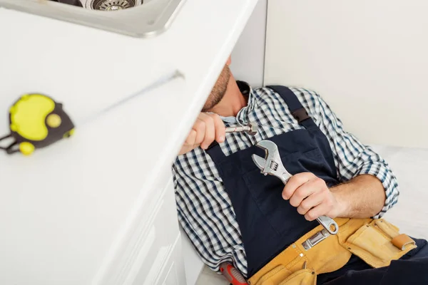 Selective Focus Plumber Overalls Holding Wrench Metal Pipe While Fixing — Stock Photo, Image