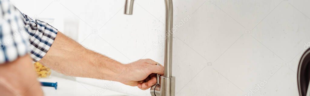 Panoramic orientation of plumber fixing kitchen faucet 
